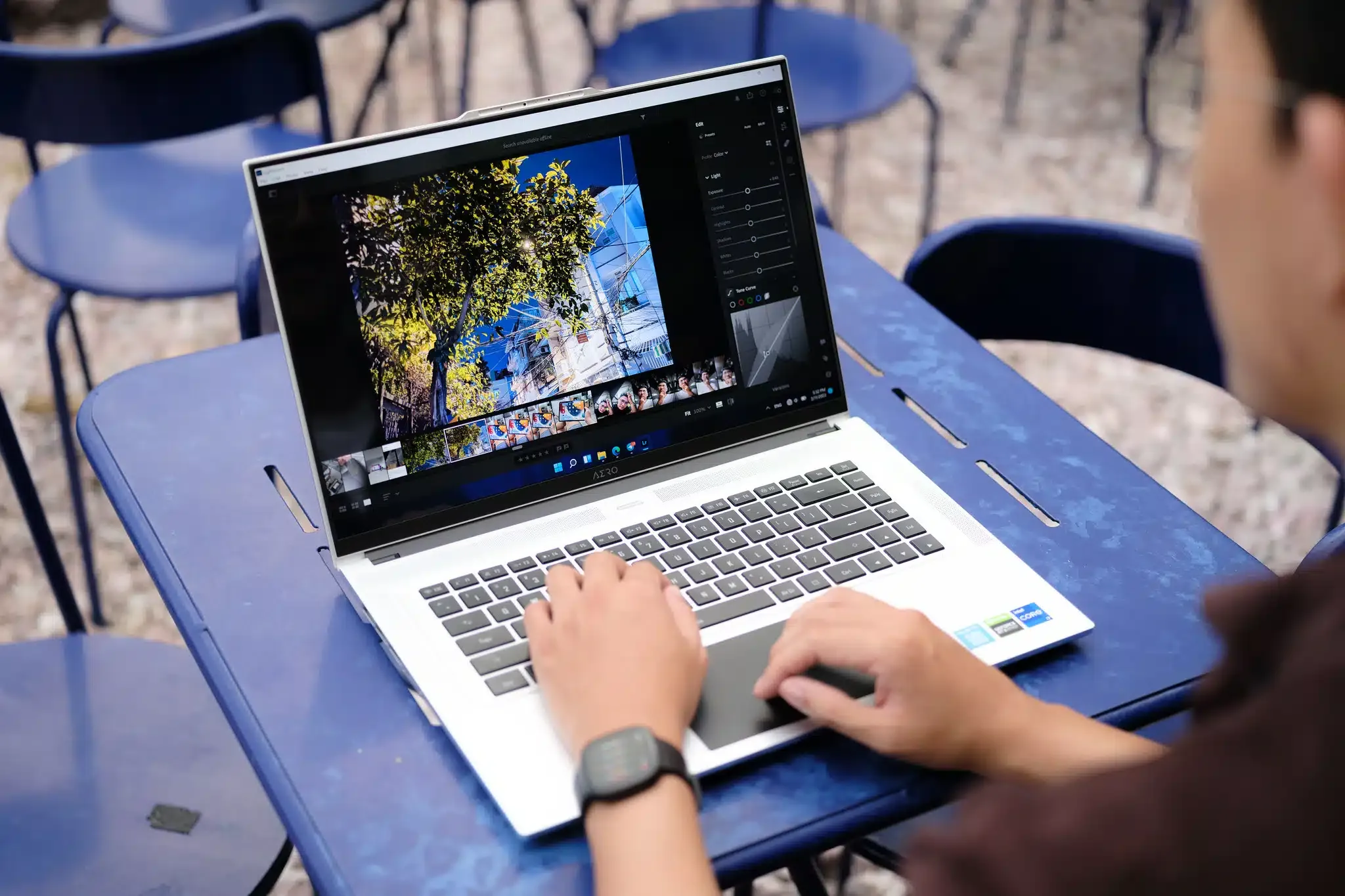 iPhone kết nối qua cáp USB-A/C với máy tính Windows để chuyển dữ liệu ảnh