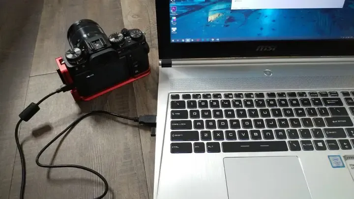 Kỹ thuật viên thực hiện cách chuyển ảnh từ máy ảnh Sony sang máy tính qua đầu đọc thẻ nhớ SD