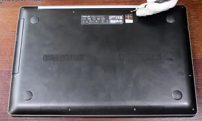 Sử dụng tuốc nơ vít để tháo các ốc vít cố định nắp đáy, bước đầu tiên trong cách tháo pin máy tính liền