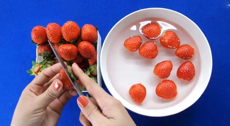 Sơ chế và ngâm dâu tây trong nước muối trước khi làm mứt