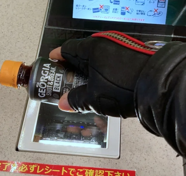 Khách hàng đang quét mã vạch sản phẩm, bước đầu tiên trong việc sử dụng máy tính tiền màn hình nổi tại cửa hàng tiện lợi Nhật Bản.