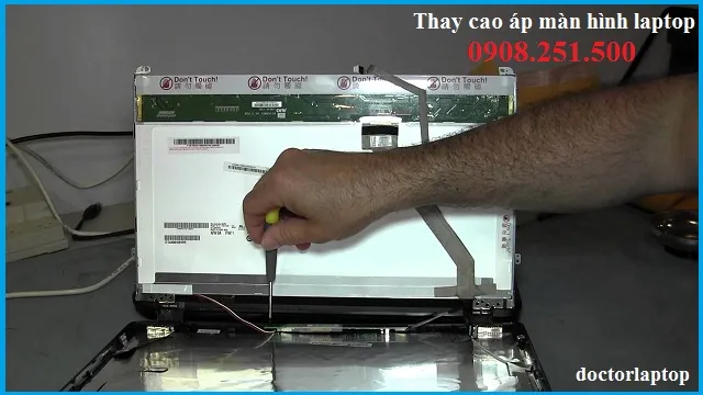 Kỹ thuật viên đang kiểm tra và sửa chữa màn hình laptop bị tối mờ