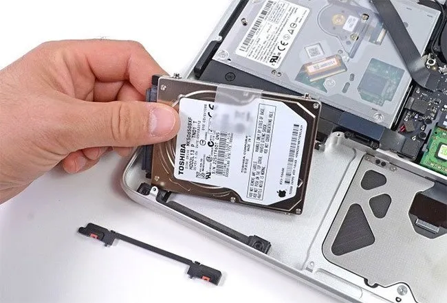 Kỹ thuật viên đang thực hiện nâng cấp ổ cứng SSD tốc độ cao để tăng tốc độ khởi động cho máy tính