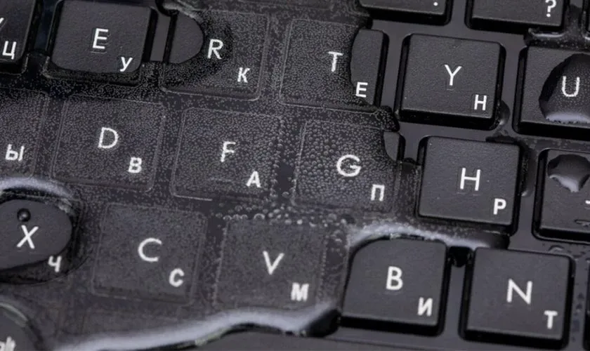 Hình ảnh mô tả việc chất lỏng và bụi bẩn bám sâu vào bên dưới các nút bấm laptop