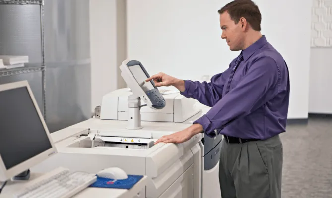 Kỹ thuật viên đang thực hiện lệnh in tài liệu trực tiếp từ máy tính để bàn