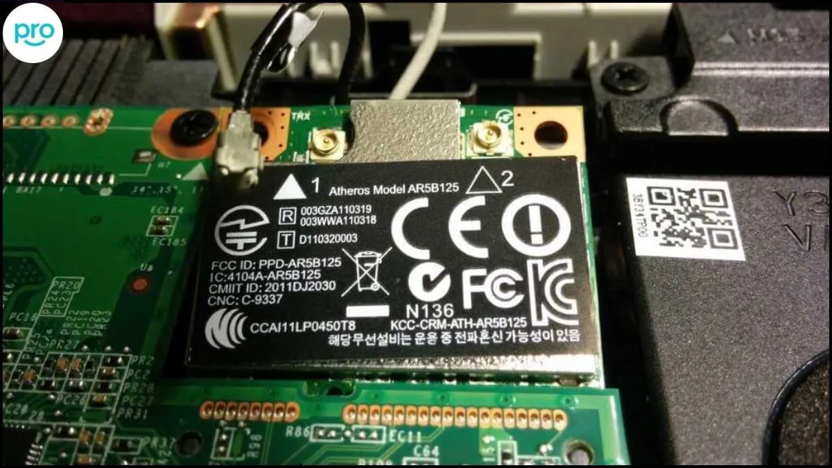 Kỹ thuật viên đang thực hiện vệ sinh và lắp đặt lại card mạng bên trong phần cứng laptop