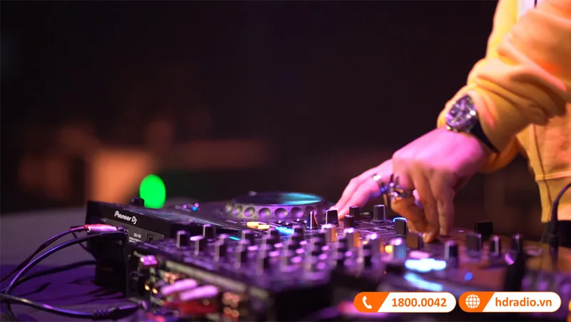 DJ đang thực hiện thao tác xoay mâm để điều chỉnh nhịp điệu bài hát khớp với nhau