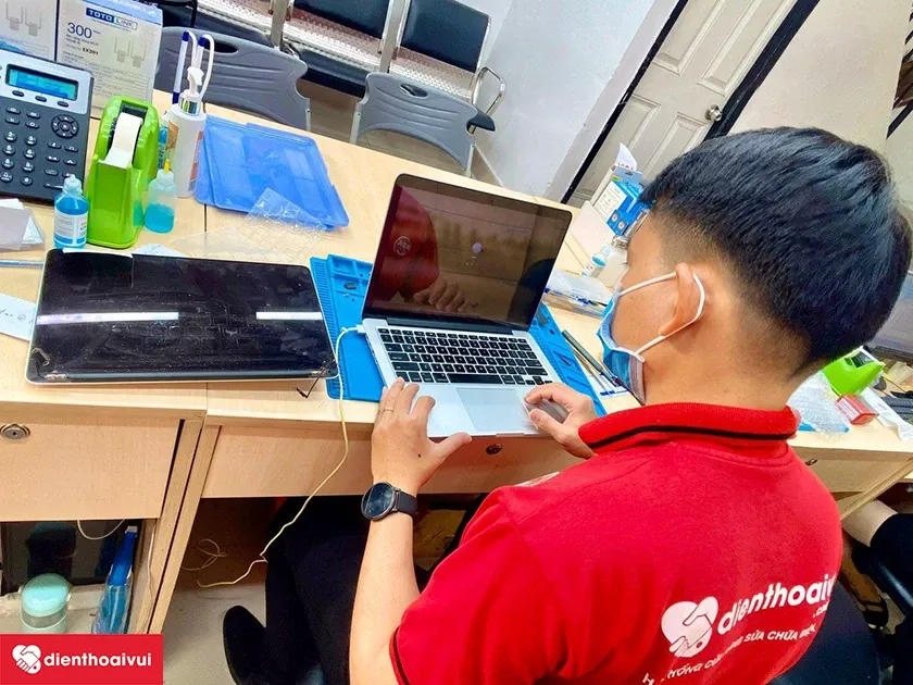 Khách hàng trực tiếp quan sát và kiểm định chất lượng màn hình sau khi thay thế tại trung tâm dịch vụ